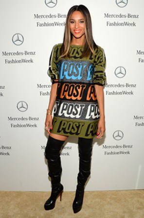 La cantante Ciara con un vestido muy peculiar estampado con la palabra "POST" en varios colores, a rayas y con unas botas negras largas.