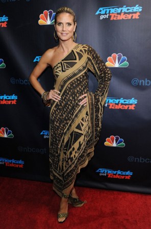 Más que vestido Heidi Klum parece haber seleccionado una túnica en tonos dorado y negro, dejando un brazo el descubierto.