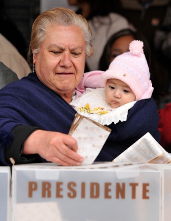 En Atlacomulco, una mujuer deposita su voto.