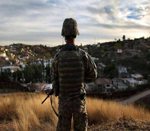 NOGALES, AZ - DECEMBER 07: An Arizona National Guardsman watches over the U.S. border with Mexico at an observation post on December 7, 2010 in Nogales, Arizona. The Obama administration ordered more than 500 soldiers placed along the Arizona border to man "entry identification sites" and spot illegal immigrants crossing into the United States. The troops, who have no detention authority, radio U.S. Border Patrol agents when they spot immigrants crossing. The troop deployment was meant to further bolster border security and help stem illegal immigration into Arizona, which has become a flashpoint for the issue nationwide. (Photo by John Moore/Getty Images)