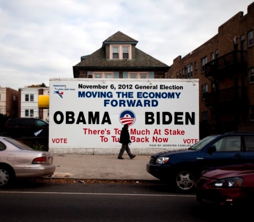 En Filadelfia, Pennsylvania, un hombre pasa por un anuncio que apoya al Presidente Barack Obama y al Vicepresidente Joe Biden.