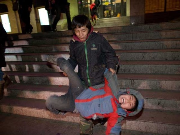 Un niño ya mayor carga a otro de menos edad, para llevarlo al Centro de Menores, en contra de su voluntad.