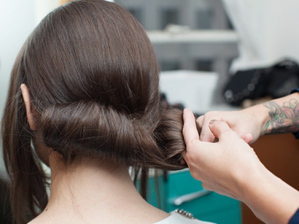Separa el cabello en dos secciones iguales y enróllalo hacia arriba. Mantén al menos un dedo en el centro para guiarte y lograr uniformidad.