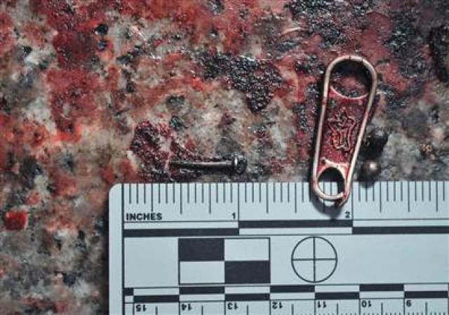 Más evidencia recogida en el lugar de los atentados. Este artefacto parace una hebilla de mochila.