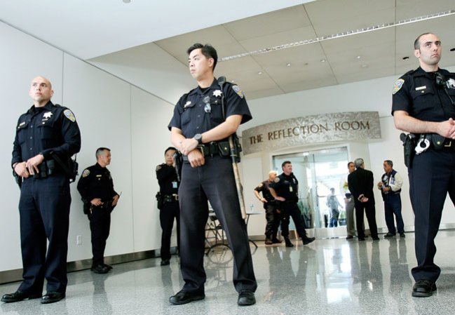 Policías custodian el lugar en el aeropuerto donde se han ido reuniendo los pasajeros que sobrevivieron y sus familiares.