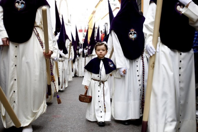 Procesión de la Cofradía de San Gonzálo en Sevilla, España. Los participantes visten los gorros y las túnicas en representación de los nazarenos.