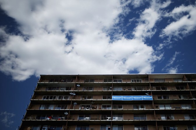 Un póster en apoyo a Obama cuelga del balcón de un apartamento frente al Ritchie Center, lugar del debate.