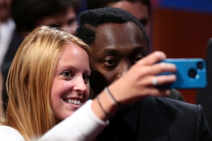 Una espectora aprovecha para tomarse una foto con el rapero Will.i.am.