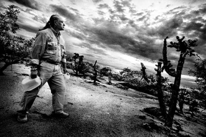 Mike Wilson, un voluntario de la organización humanitaria Humane Borders con sede en Tucson, Arizona, coloca recipientes de agua en el desierto con la esperanza de evitar más muertes de inmigrantes y conduce misiones de búsqueda a nombre de familias que quieren encontrar a sus seres queridos. Wilson es miembro de la Nación Tohono O'odham, en cuya reserva muchos de los migrantes han muerto.