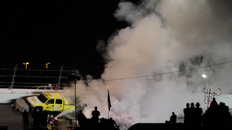 Personal de seguridad procede a intentar apagar el fuego en el Daytona International Speedway, en Daytona Beach, Florida.
