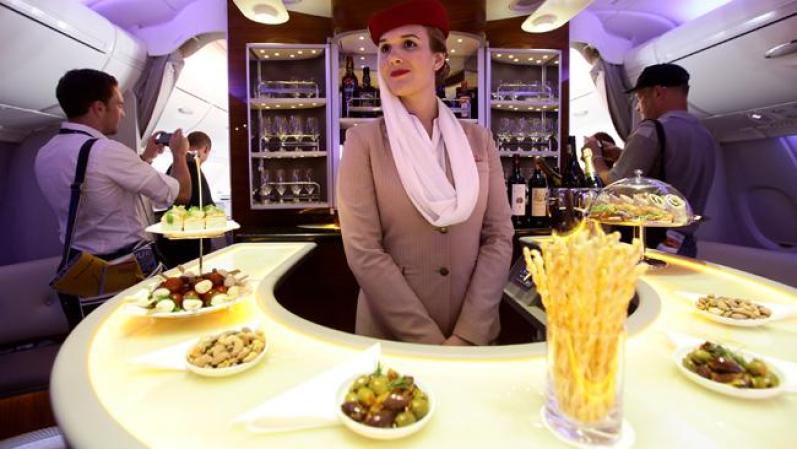 Una azafata de Emirates atiende en la zona de primera clase de sus distinguidos aviones.