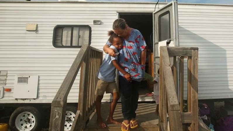 Una familia de cuatro adultos y siete niños comparte una casa móvil en Port Sulphur, Luisiana.
