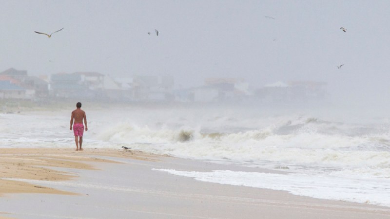 ST GEORGE ISLAND, FL - JUNE 6: A man walks on the beach in the heavy rain and surf June 6, 2013 in St. George Island, Florida. Tropical Storm Andrea, the first tropical storm of the season, is expected to bring heavy rains across Florida before heading up the East Coast. (Photo by Mark Wallheiser/Getty Images)