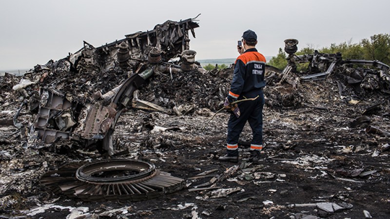 Un trabajador de los servicios de emergencia fotos a los escombros del vuelo MH17.