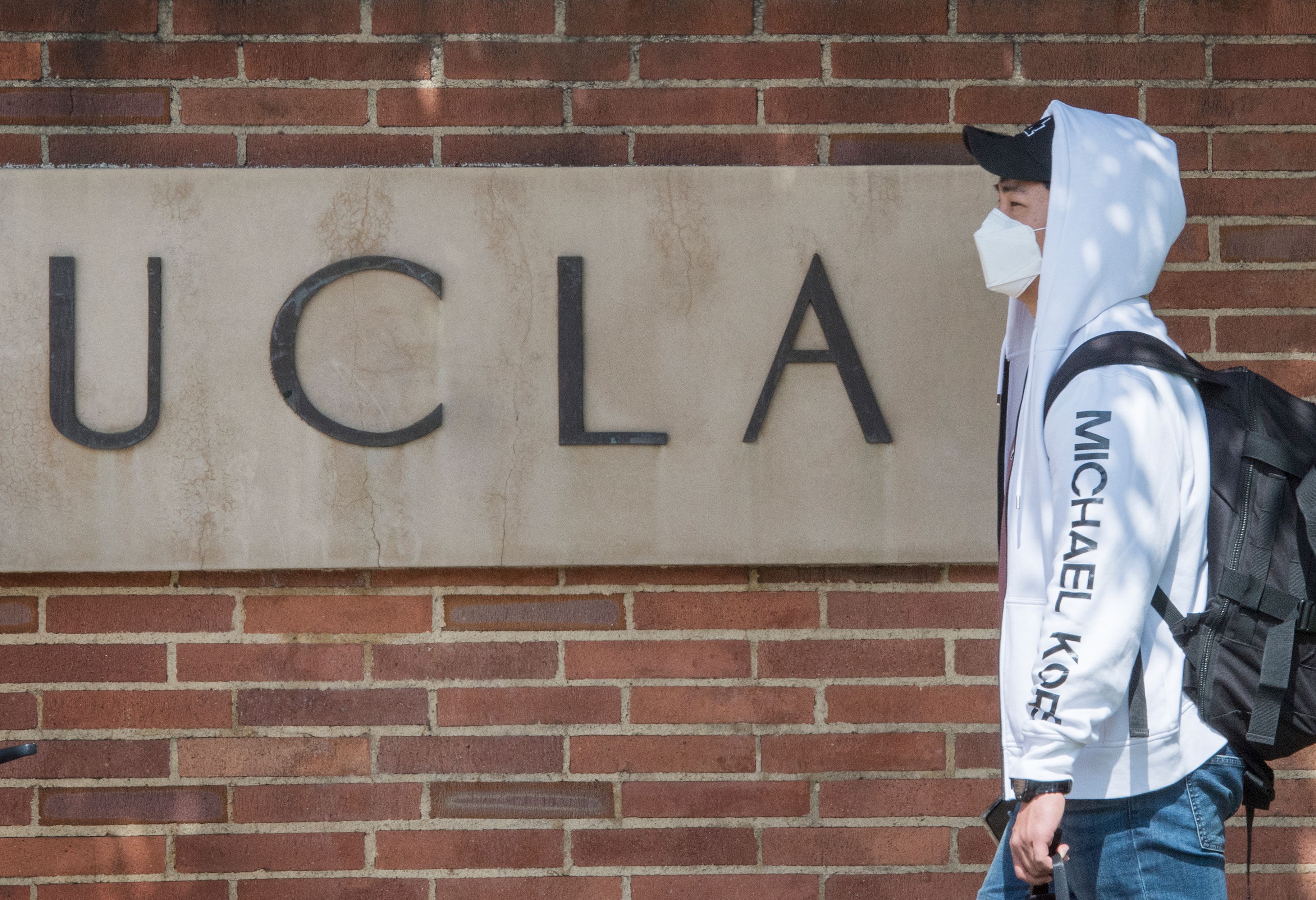 Un estudiante usa una máscara facial para protegerse contra el COVID-19 (Coronavirus) tras salir del campus de la universidad de UCLA en Westwood, California, el 6 de marzo de 2020. - Tres estudiantes de UCLA estaban siendo examinados para detectar el COVID-19 (coronavirus) por el Departamento de Salud Pública de Los Ángeles, según el rector de UCLA, Gene Block. (Foto de Mark RALSTON / AFP) (Foto de MARK RALSTON / AFP a través de Getty Images)