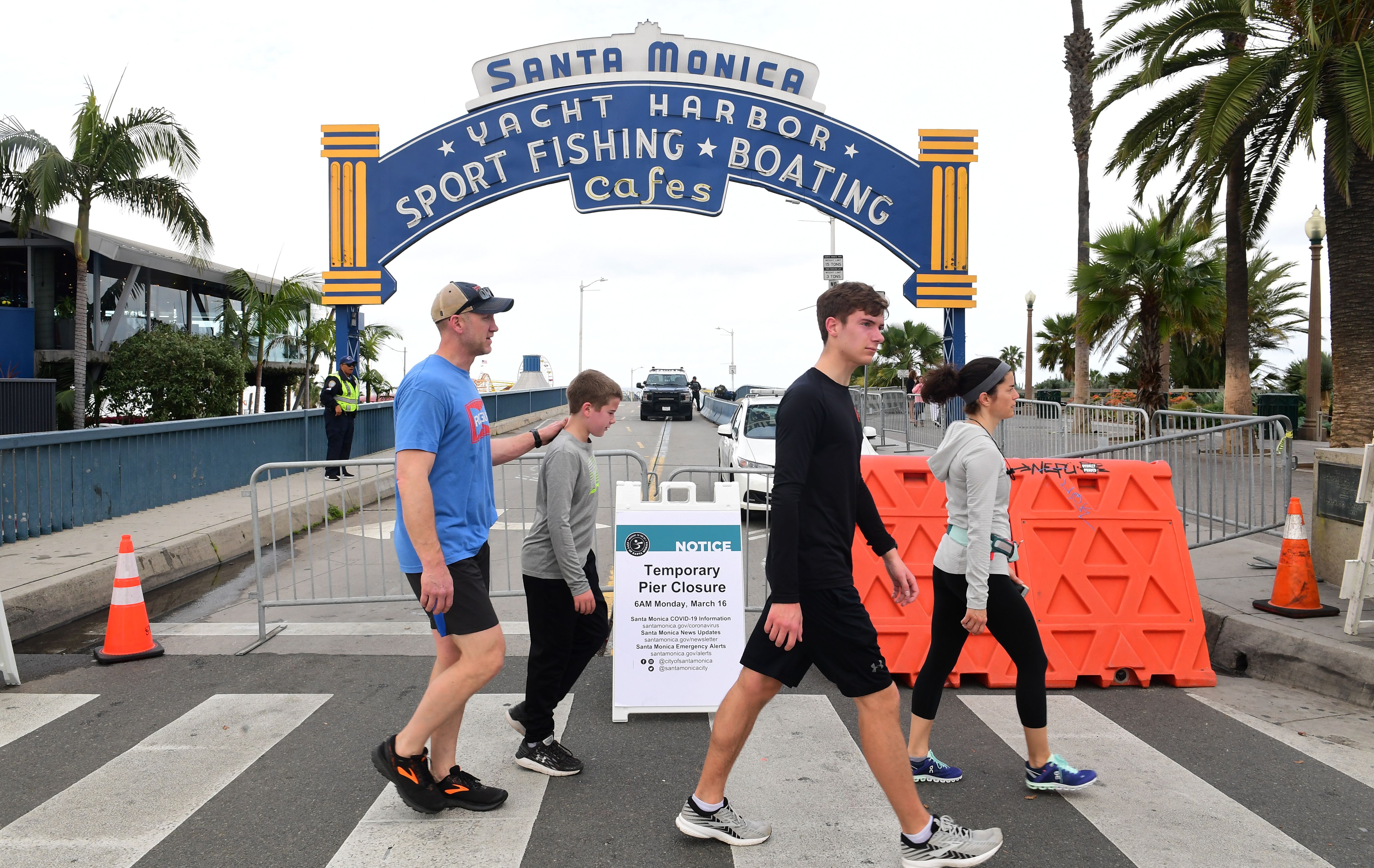 La gente pasa junto a un muelle cerrado de Santa Mónica, una de las atracciones turísticas más populares del sur de California el 16 de marzo de 2020 en Santa Mónica, California, mientras la pandemia de Coronavirus detiene gran parte de California. - Las existencias se desplomaron el 16 de marzo de 2020 a pesar de las medidas de emergencia del banco central para apuntalar la economía mundial afectada por el virus, a medida que los países de Europa comenzaron la semana en el cierre y las principales ciudades de EE. UU. Cerraron bares y restaurantes. El virus ha trastornado a la sociedad en todo el planeta, con gobiernos que imponen restricciones que rara vez se ven fuera del tiempo de guerra, incluido el cierre de fronteras, las órdenes de cuarentena doméstica y el desguace de eventos públicos, incluidos los principales eventos deportivos. (Foto de Frederic J. BROWN / AFP) (Foto de FREDERIC J. BROWN / AFP a través de Getty Images)