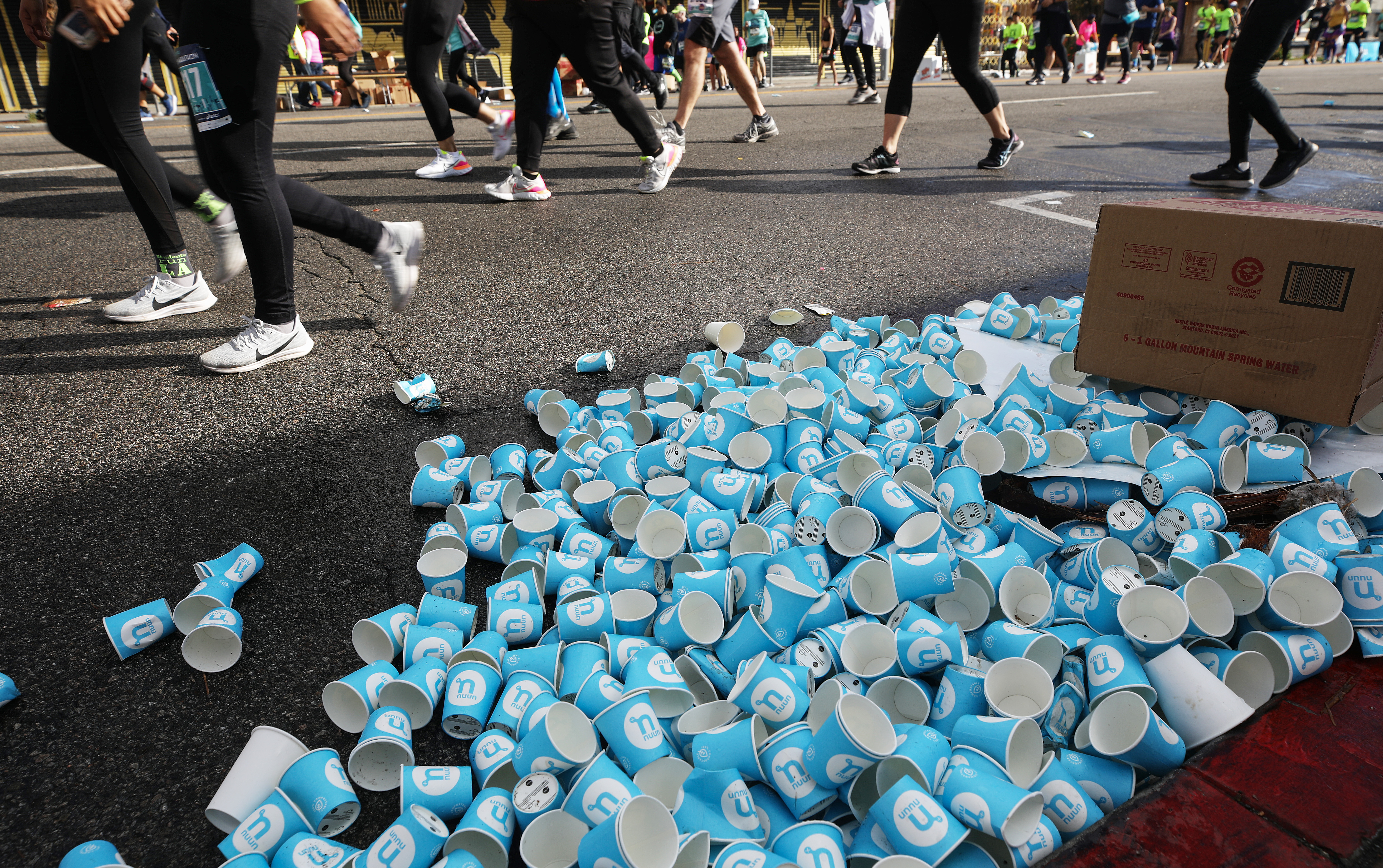LOS ÁNGELES, CALIFORNIA - 8 DE MARZO: Los corredores pasan tazas desechadas durante el maratón de Los Ángeles, que los funcionarios de salud permitieron que continuara a pesar de los temores del coronavirus COVID-19, el 8 de marzo de 2020 en Los Ángeles, California. Los funcionarios de salud del condado de Los Ángeles recomendaron que las personas enfermas, incluidos los corredores, se quedaran en casa y que los corredores debían evitar darse la mano. El maratón, con más de 25,000 participantes en el campo de carreras de los 50 estados y 78 naciones, es uno de los corredores más grandes de los EE. UU. Cuya dirección postal estaba en China, Hong Kong, Italia, Taiwán, Irán y Corea del Sur se aplazó hasta la próxima carrera del año (Foto de Mario Tama / Getty Images)<br><br>