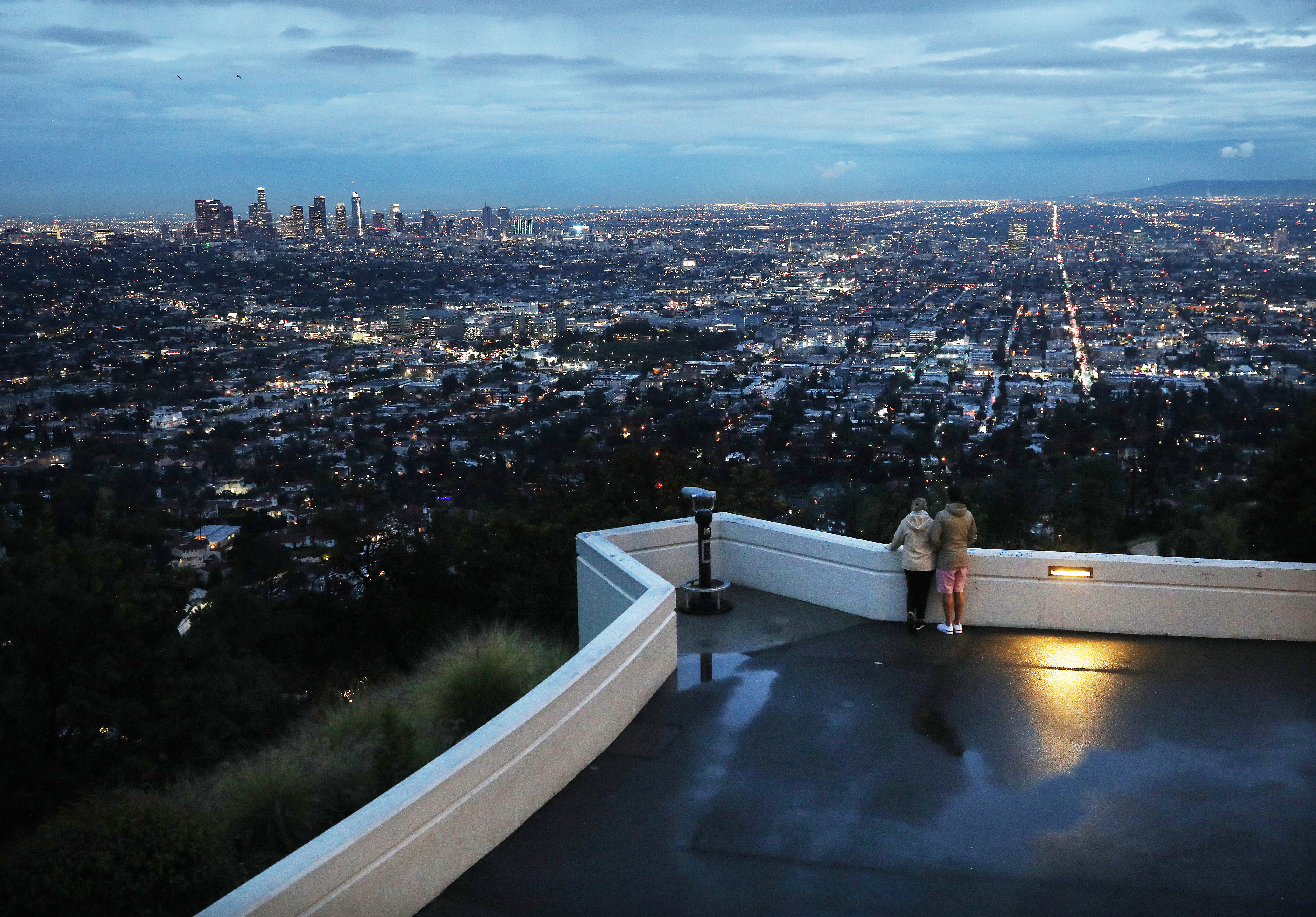 <br>Los visitantes ven el horizonte de la ciudad al atardecer desde una terraza en el Observatorio Griffith, cerrado debido a la propagación del coronavirus, el 12 de marzo de 2020 en Los Ángeles, California. (Foto de Mario Tama / Getty Images)