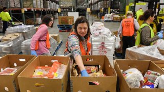Kelly Schnur helps to load boxes at the Helping Harvest food bank