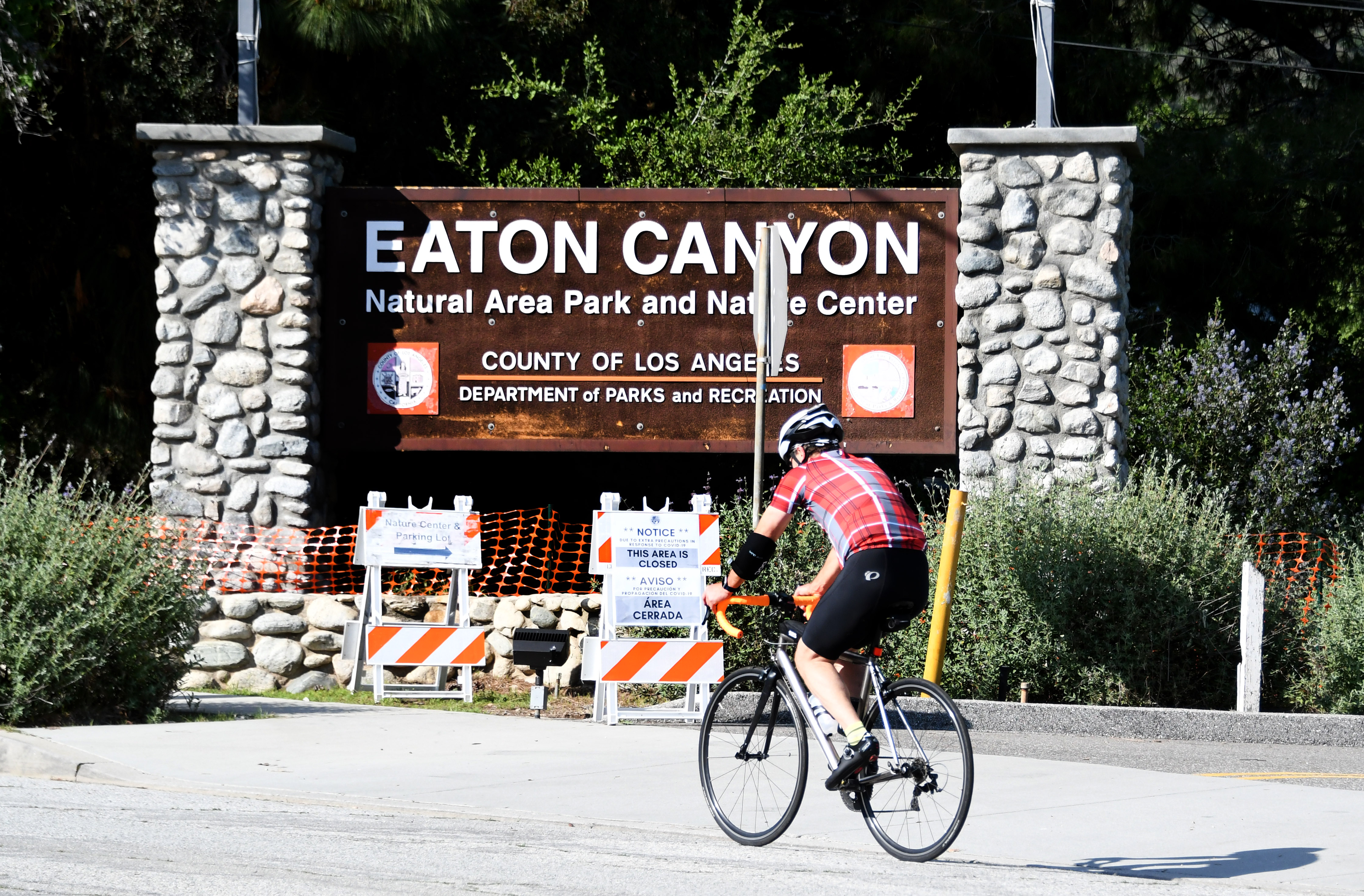Un ciclista pasa junto al  Parque Natural y el Centro Natural Eaton Canyon que está cerrado debido a la pandemia de coronavirus en Altadena, el martes 14 de abril de 2020. (Foto de Keith Birmingham / MediaNews Group / Pasadena Star-News a través de Getty Images)