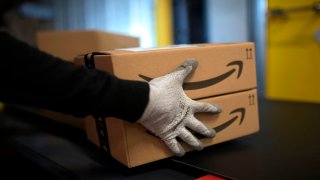 An employee carries a package at the distribution center of US online retail giant Amazon