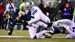 Carson Wentz #11 of the Philadelphia Eagles is tackled by Antwaun Woods #99 of the Dallas Cowboys and Kerry Hyder #51 during the second quarter at Lincoln Financial Field on Dec. 22, 2019 in Philadelphia, Pennsylvania.