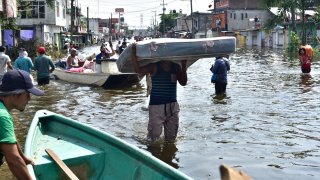 Pobladores de Tabasco caminan en calles inundadas