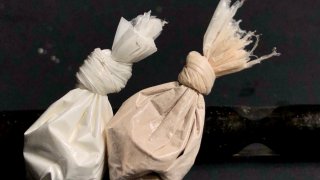 Cocaine and heroin in bags with stem in background