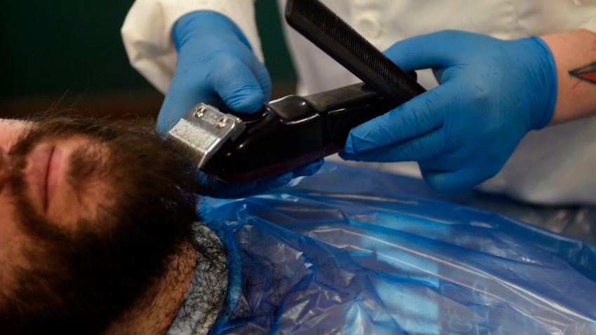 Hairdresser David Cores trims his first client’s beard after reopening his barber shop in Pontevedra, on May 4, 2020, for the first time since the beginning of a national lockdown to prevent the spread of the COVID-19 disease. – Masks became mandatory on public transport today as Spain took its first tentative steps towards a commercial reopening with small businesses accepting customers by appointment and restaurants prepping food for takeaway. Spain’s population of nearly 47 million people have been confined to their homes for more than 50 days as the country sought to curb the spread of the deadly virus which has so far claimed 25,428 lives. (Photo by MIGUEL RIOPA / AFP) (Photo by MIGUEL RIOPA/AFP via Getty Images)