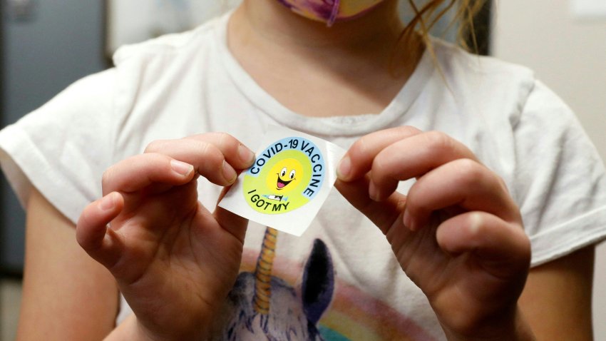 A 6 year-old child holds a sticker she received after getting the Pfizer-BioNTech Covid-19 vaccine at the Child Health Associates office in Novi, Michigan on November 3, 2021. – An expert panel unanimously recommended Pfizer-BioNTech’s Covid vaccine for five- to 11-year-olds on November 2, the penultimate step in the process that will allow injections in young children to begin this week in the United States. The Centers for Disease Control and Prevention (CDC), the top US public health agency, was expected to endorse that recommendation later in the day. (Photo by JEFF KOWALSKY / AFP) (Photo by JEFF KOWALSKY/AFP via Getty Images)