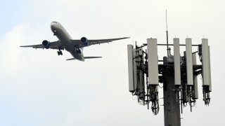 A cellular tower stands as a United Airlines Boeing 787 Dreamliner airplane lands at Los Angeles International Airport