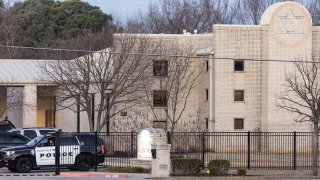 Police stand in front of the Congregation Beth Israel synagogue, Jan. 16, 2022, in Colleyville, Texas.