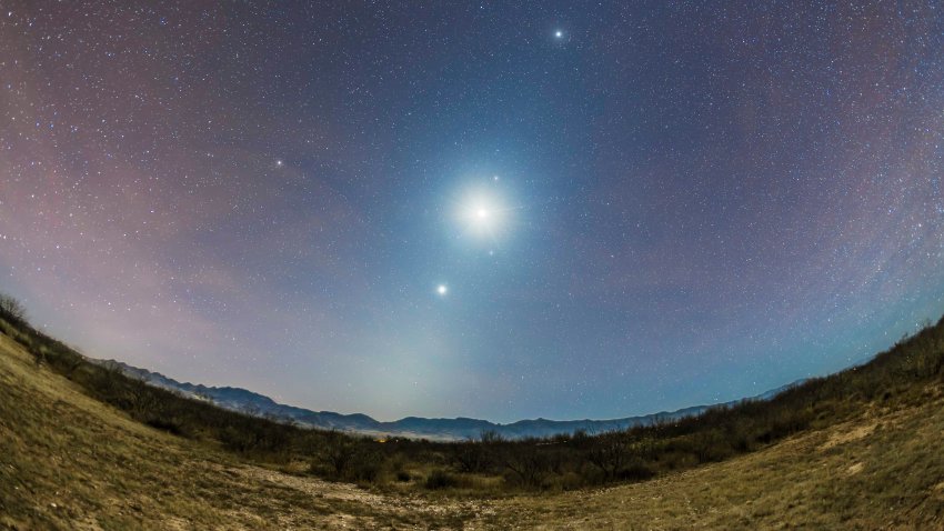 The Zodiacal Light of a late autumn/early winter morning faintly visible amid the moonlight from the waning crescent Moon, at centre here as the brightest object, flaked by three planets: Venus the brightest below, Mars, just above the Moon, and Jupiter, the bright object at top. The Moon and three planets define the morning ecliptic line and the angle of the Zodiacal Light which follows the ecliptic. Taken from Quailway Cottage on Dec 6, 2015 when shooting Comet Catalina, from Arizona but here looking east to New Mexico. Airglow adds the bands of red colour. Spica lies just below and to the right of the Moon. (Photo by: Alan Dyer /VW PICS/Universal Images Group via Getty Images)