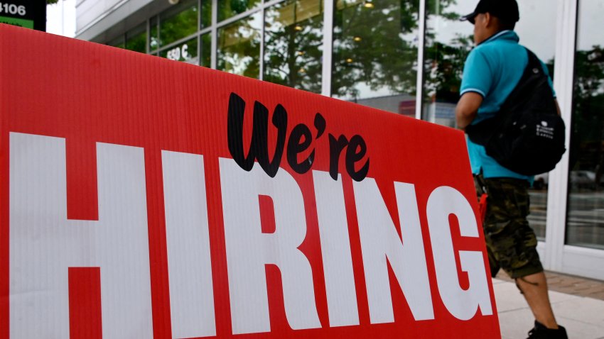 A man walks past a “We’re Hiring” sign posted in Arlington, Virginia on June 3, 2022.