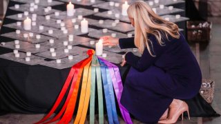 La princesa noruega Mette-Marit enciende velas durante un servicio de duelo en la Catedral de Oslo el 26 de junio de 2022, un día después de un tiroteo afuera de pubs y clubes nocturnos que mató a dos personas e hirió a unas 20.