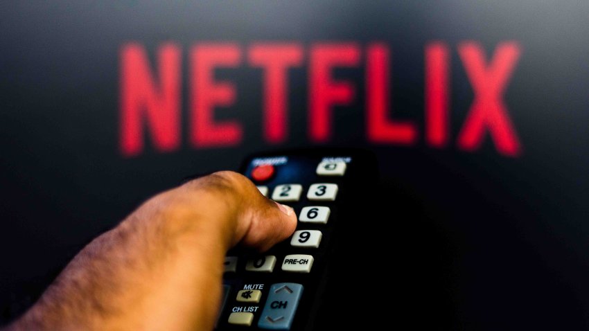 March 12, 2019, Brazil. Man with TV remote control in hand and Netflix logo in background. Netflix is ​​the global provider of streaming movies and TV series.