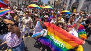 Los manifestantes con Starbucks pasan por la histórica intersección de Hollywood y Highland durante el Desfile del Orgullo Gay anual en Los Ángeles, el 12 de junio de 2022.