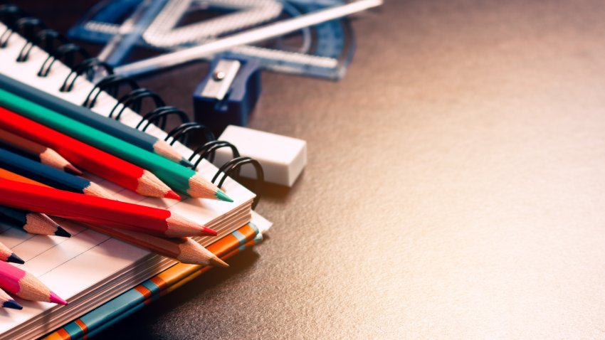 Color pencil on student table and notebook with education concept.