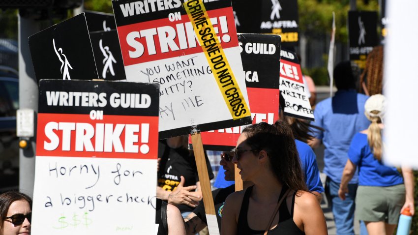 Members of the Writers Guild of America and the Screen Actors Guild walk the picket line outside Paramount Studios in Los Angeles, California, on July 19, 2023. Tens of thousands of Hollywood actors went on strike at midnight July 13, 2023, effectively bringing the giant movie and television business to a halt as they join writers in the first industry-wide walkout for 63 years. (Photo by VALERIE MACON / AFP) (Photo by VALERIE MACON/AFP via Getty Images)