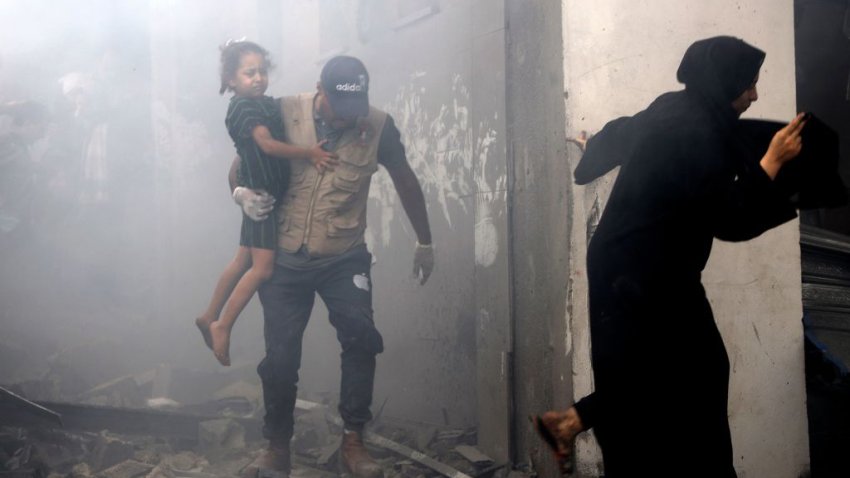 Members of a Palestinian family rush out of a bombed house during Israeli airstrikes on Gaza City on October 9, 2023. Stunned by the unprecedented assault on its territory, a grieving Israel has counted over 700 dead and launched a withering barrage of strikes on Gaza that have raised the death toll there to 493 according to Palestinian officials. (Photo by Eyad AL-BABA / AFP) (Photo by EYAD AL-BABA/AFP via Getty Images)