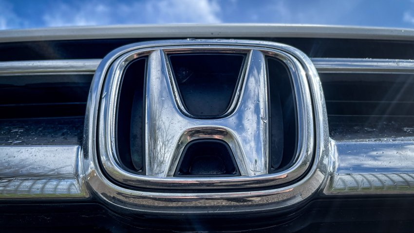 A view of the Honda Motor Company logo on the front grille of a Honda car.