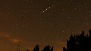 ARCHIVO – En esta fotografía de larga exposición, aparece una raya en el cielo durante la lluvia anual de meteoros Perseidas en las montañas de Guadarrama, cerca de Madrid, en las primeras horas del 12 de agosto de 2016.