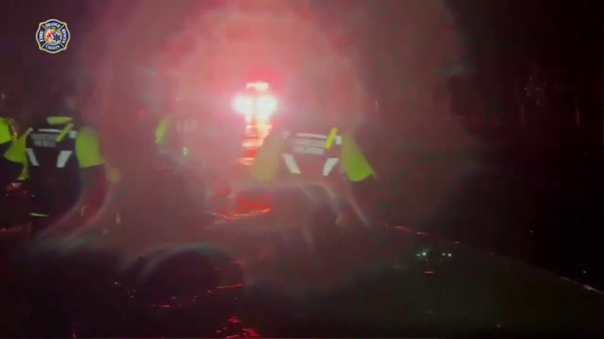Equipos de emergencia en el condado Orange, cerca de Orland,  navegan aguas inundadas