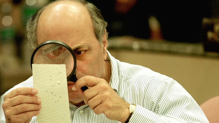 382382 03: (FILE PHOTO) Judge Robert Rosenberg of the Broward County Canvassing Board uses a magnifying glass to examine a dimpled chad on a punch card ballot November 24, 2000 during a vote recount in Fort Lauderdale, Florida. On May 4, 2001 the Florida state legislature overwhelmingly passed a voting reform act designed to eliminate the controversial punch card ballots which were the focal point of recount efforts in the 2000 presidential election. (Photo by Robert King/Newsmakers)