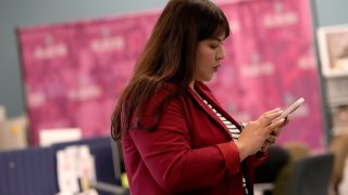 Reyna Montoya, directora de Aliento, una organización defensora de inmigrantes, revisa su teléfono en su oficina en Phoenix, Arizona, el 12 de noviembre de 2024.