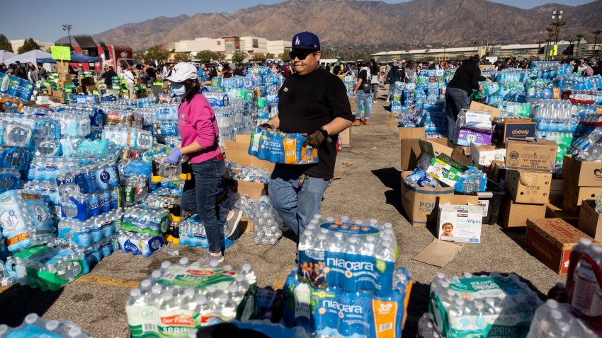 Voluntarios transportan agua para los evacuados por el incendio de Eaton en un centro de donaciones en Santa Anita Park, Arcadia, California, el 13 de enero de 2025.