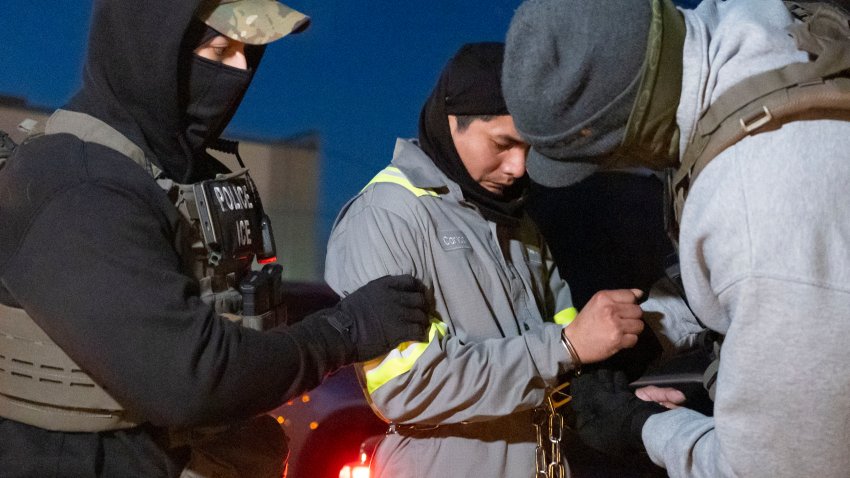 Agentes del Servicio de Control de Inmigración y Aduanas de Estados Unidos utilizan una cadena para manejar mejor a una persona que ya trae esposas, el lunes 27 de enero de 2025, en Silver Spring, Maryland. (AP Foto/Alex Brandon)