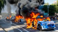 A row of Waymo vehicles burn on a street during an anti-ICE protest in downtown Los Angeles, California, on June 8, 2025.