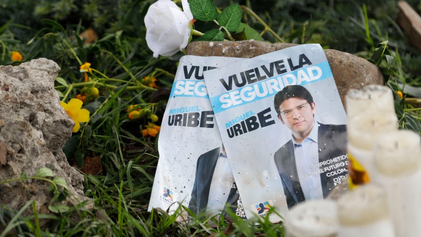 Panfletos con la imagen del senador colombiano Miguel Uribe Turbay, junto a velas y flores, colocadas junto al lugar en el que fue disparado durante un mitin político en Bogotá, Colombia, el lunes 9 de junio de 2025. (AP Foto/John Vizcaíno)