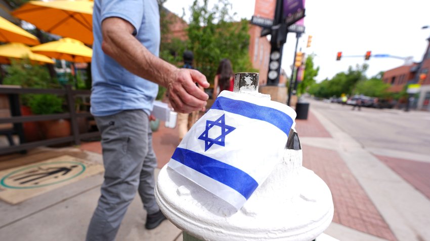 Un transeúnte toca una bandera israelí colocada en Pearl Street Mall cerca de los tribunales en Boulder, Colorado, el 2 de junio del 2025.  (AP foto/David Zalubowski)